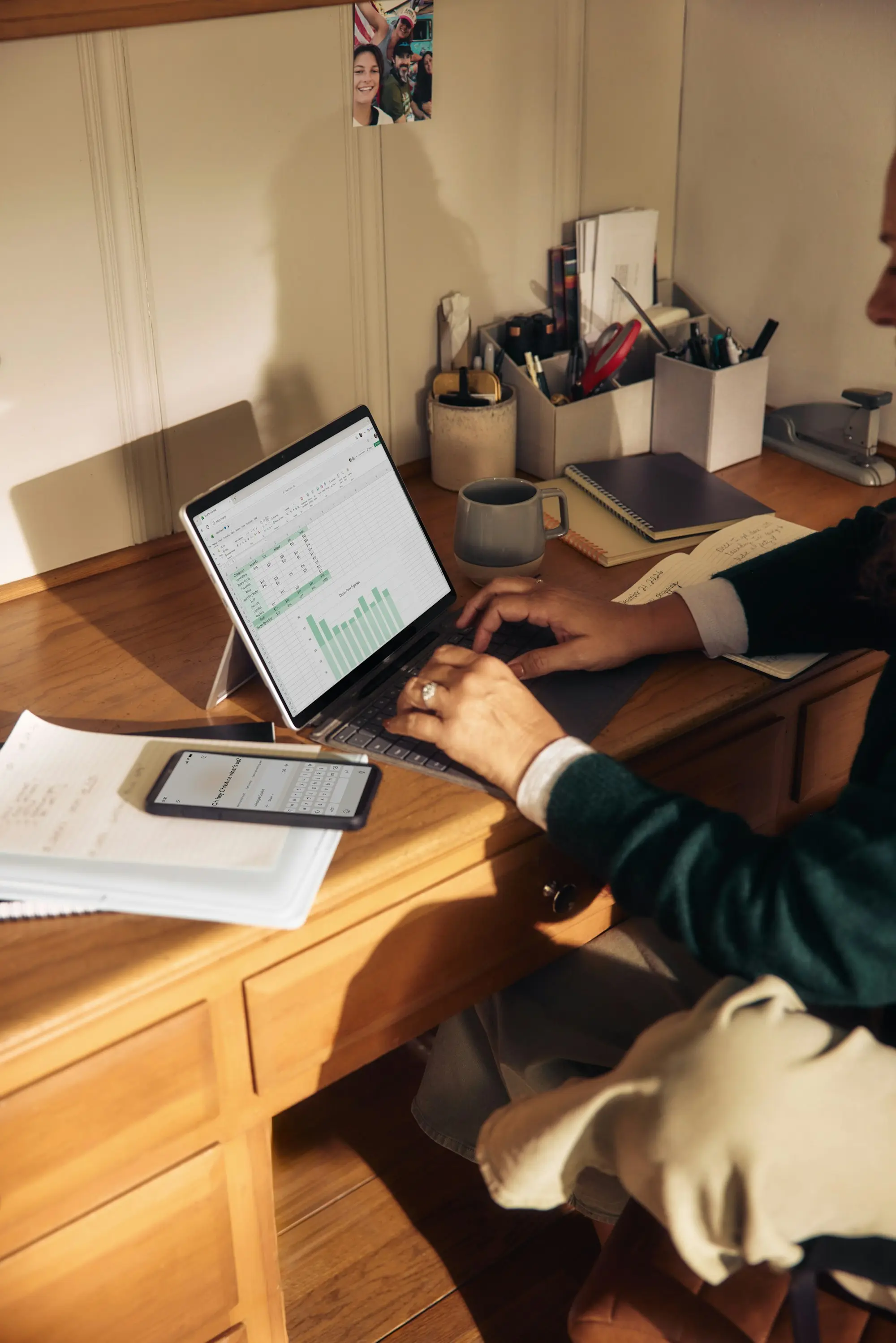 Deux mains saisissent des chiffres dans un tableur sur un ordinateur portable